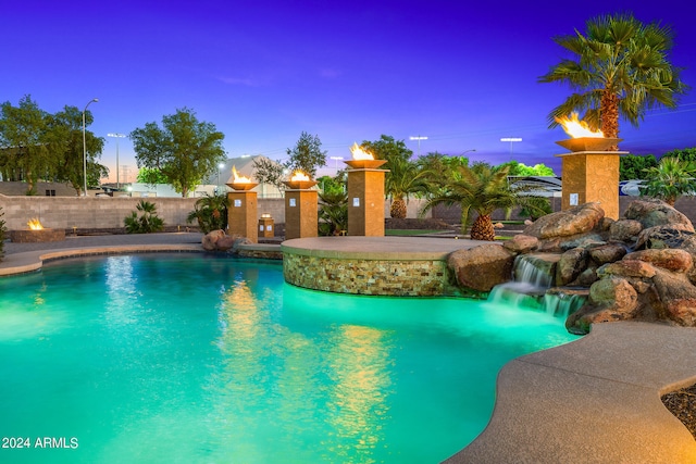 pool at dusk with pool water feature