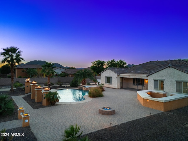 pool at dusk featuring a patio area