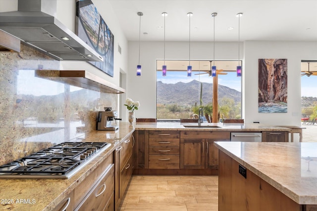 kitchen featuring wall chimney exhaust hood, sink, tasteful backsplash, a mountain view, and stainless steel appliances