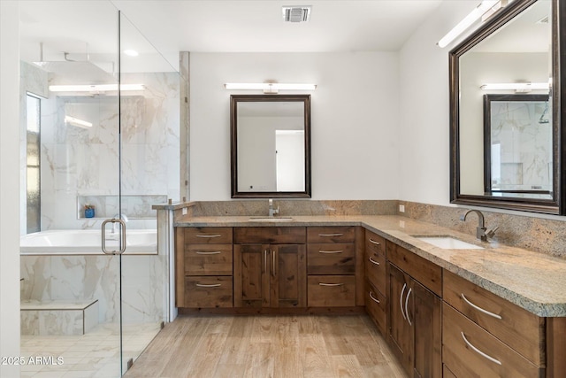 bathroom with hardwood / wood-style flooring, vanity, and separate shower and tub