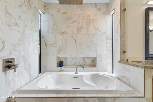 bathroom featuring a relaxing tiled tub and tile walls