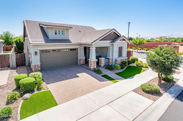 2611 S Quaintance St, Gilbert, AZ 85295 - craftsman inspired home featuring stone siding, fence, decorative driveway, and stucco siding
