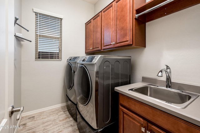 2611 S Quaintance St, Gilbert, AZ 85295 - laundry room featuring independent washer and dryer, cabinet space, light wood-style floors, and baseboards