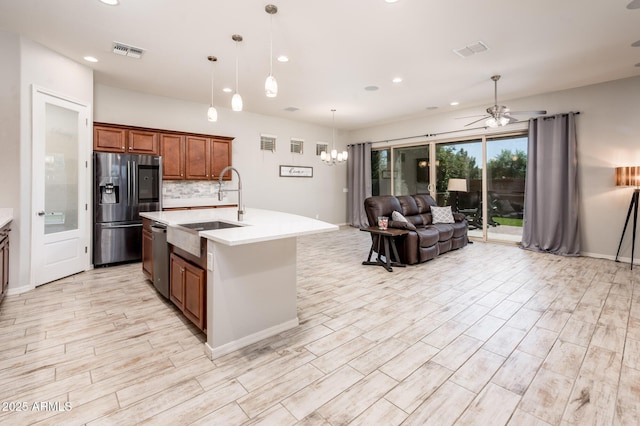 2611 S Quaintance St, Gilbert, AZ 85295 - kitchen featuring stainless steel appliances, a sink, light countertops, open floor plan, and brown cabinetry