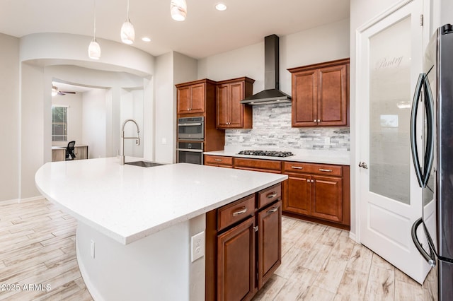 2611 S Quaintance St, Gilbert, AZ 85295 - kitchen featuring wall chimney exhaust hood, appliances with stainless steel finishes, tasteful backsplash, a sink, and a kitchen island with sink