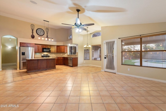 kitchen featuring pendant lighting, stainless steel appliances, a center island, tasteful backsplash, and light tile patterned flooring