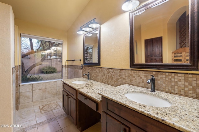 bathroom featuring lofted ceiling, vanity, tile patterned flooring, and tile walls