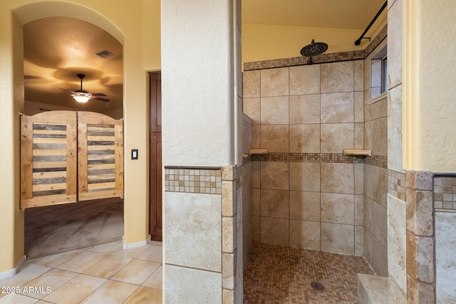 bathroom with tile patterned flooring, a tile shower, ceiling fan, and tile walls