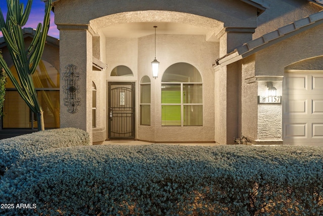 exterior entry at dusk with a garage