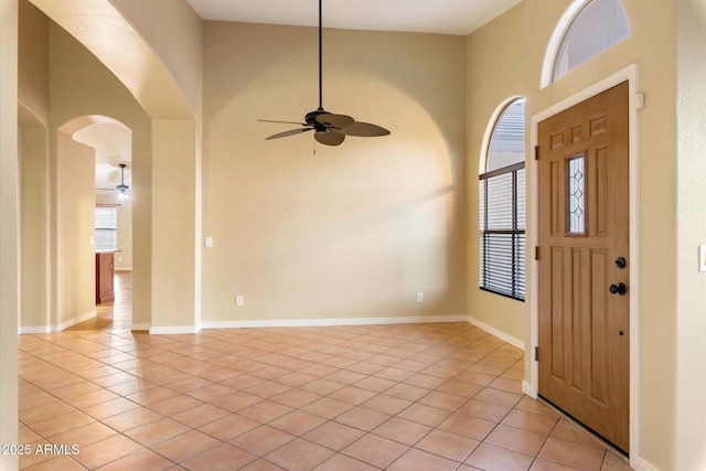 entryway featuring light tile patterned flooring, ceiling fan, and a high ceiling