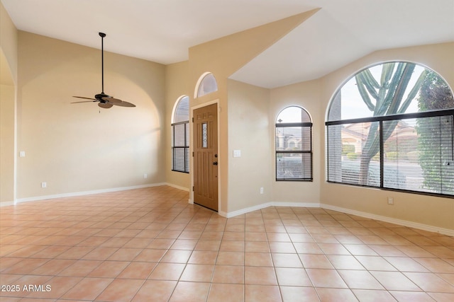 tiled spare room with ceiling fan and vaulted ceiling