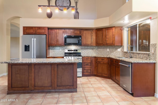 kitchen with light stone counters, sink, tasteful backsplash, and appliances with stainless steel finishes