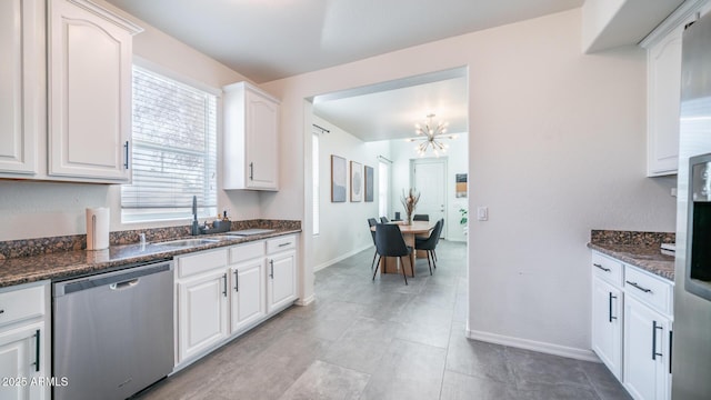 kitchen with dishwasher, white cabinets, dark stone counters, and sink