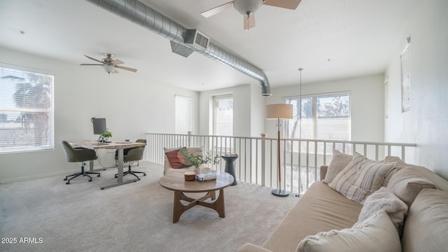 living room featuring carpet floors, ceiling fan, and a healthy amount of sunlight