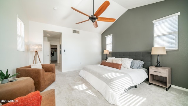 carpeted bedroom featuring ceiling fan, multiple windows, and vaulted ceiling