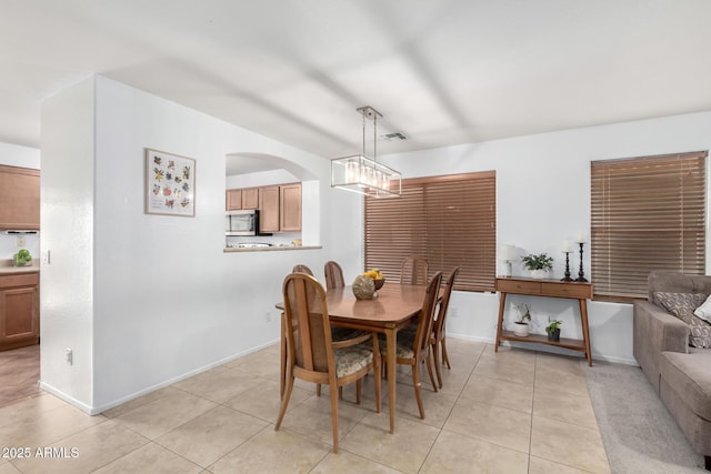 dining area with light tile patterned floors, a chandelier, and baseboards