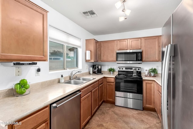 kitchen with visible vents, light countertops, appliances with stainless steel finishes, light tile patterned flooring, and a sink