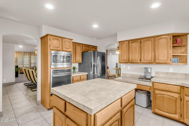 7763 W Libby St, Glendale, AZ 85308 - kitchen with open shelves, arched walkways, tile counters, and stainless steel appliances