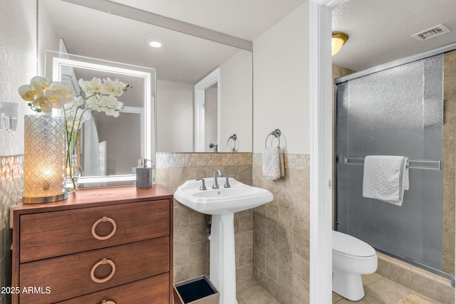 7763 W Libby St, Glendale, AZ 85308 - full bath with a shower stall, tile walls, toilet, tile patterned flooring, and visible vents