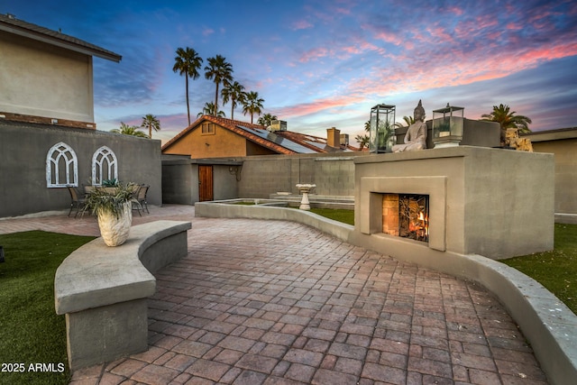 7763 W Libby St, Glendale, AZ 85308 - view of patio / terrace featuring a warm lit fireplace