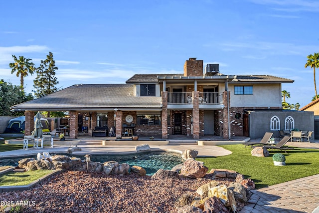 7763 W Libby St, Glendale, AZ 85308 - back of property featuring a chimney, brick siding, a patio, a balcony, and an outdoor pool