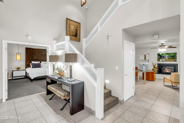 7763 W Libby St, Glendale, AZ 85308 - stairs featuring carpet flooring, a glass covered fireplace, a towering ceiling, tile patterned flooring, and ceiling fan