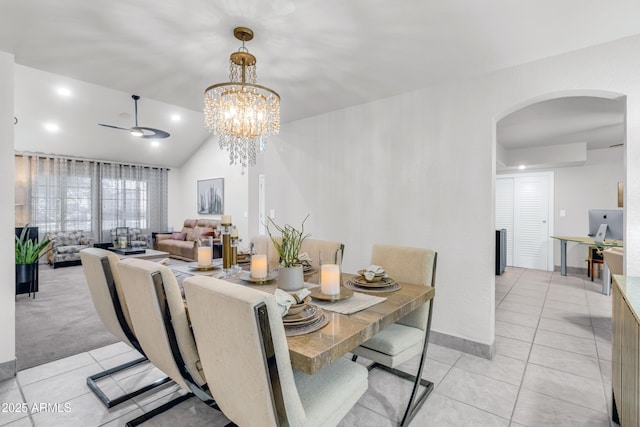7763 W Libby St, Glendale, AZ 85308 - dining space featuring ceiling fan with notable chandelier, vaulted ceiling, arched walkways, and light tile patterned floors