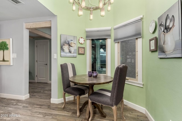 dining area featuring wood-type flooring and a chandelier