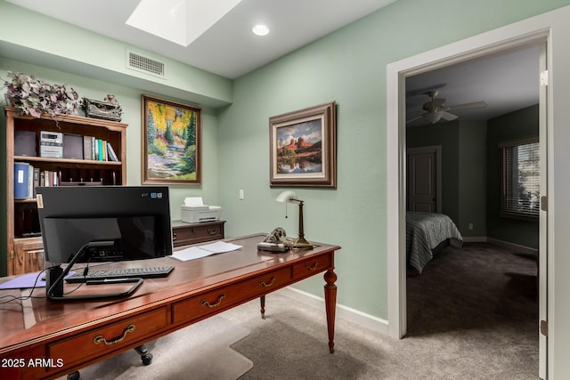 office featuring light carpet, a skylight, and ceiling fan