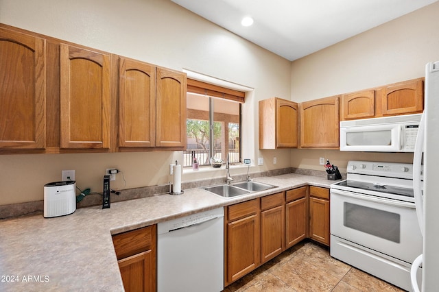 kitchen with white appliances, sink, and light tile patterned floors