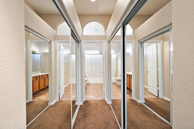 hallway featuring dark carpet