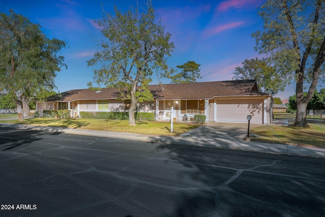 single story home with a garage and a lawn