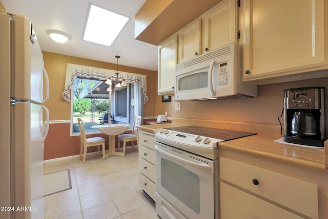 kitchen with a chandelier, light tile patterned floors, hanging light fixtures, and white appliances