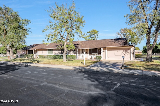 ranch-style home featuring a front lawn and a garage