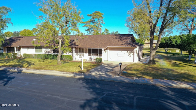 ranch-style house featuring a garage and a front lawn