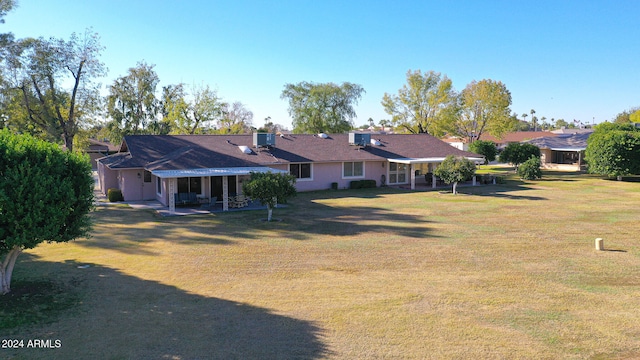 rear view of house featuring a yard