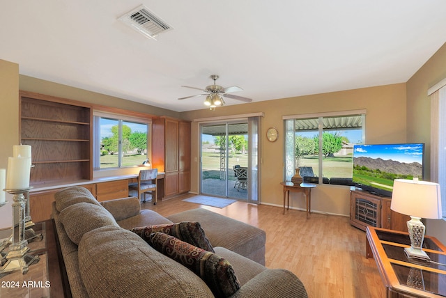 living room with ceiling fan and light wood-type flooring