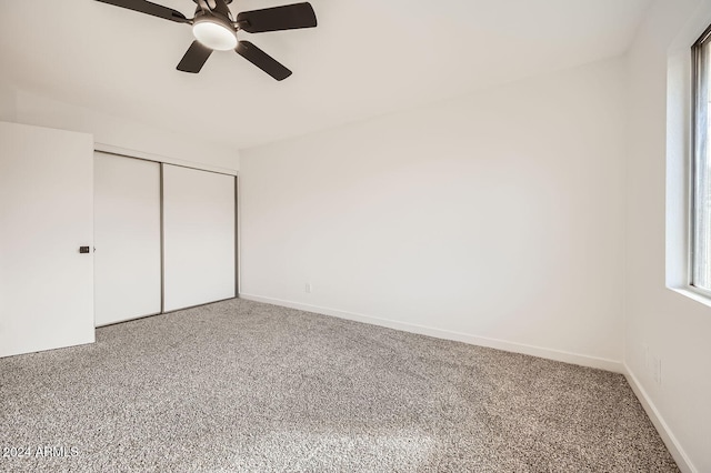 unfurnished bedroom featuring carpet, ceiling fan, and a closet