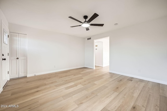 empty room with ceiling fan and light hardwood / wood-style flooring