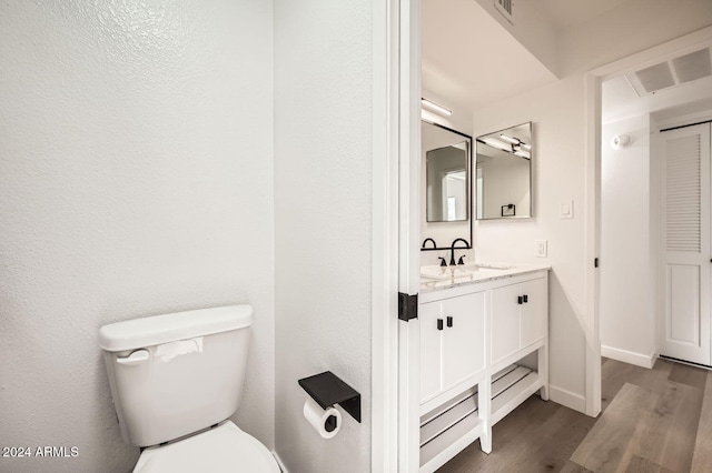 bathroom with hardwood / wood-style flooring, vanity, and toilet