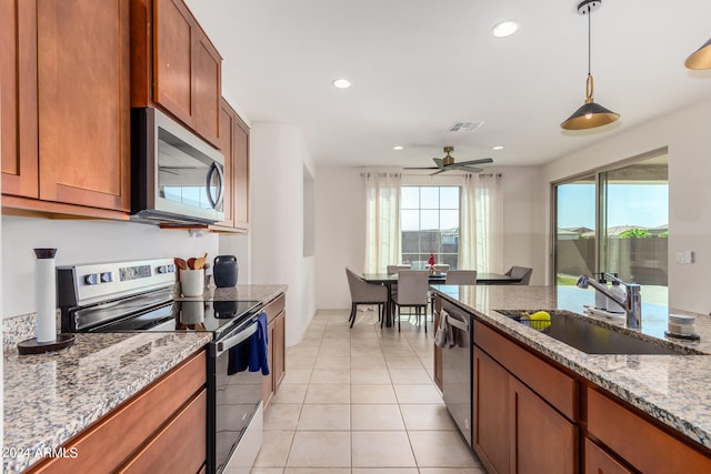 kitchen with light stone countertops, plenty of natural light, sink, and stainless steel appliances