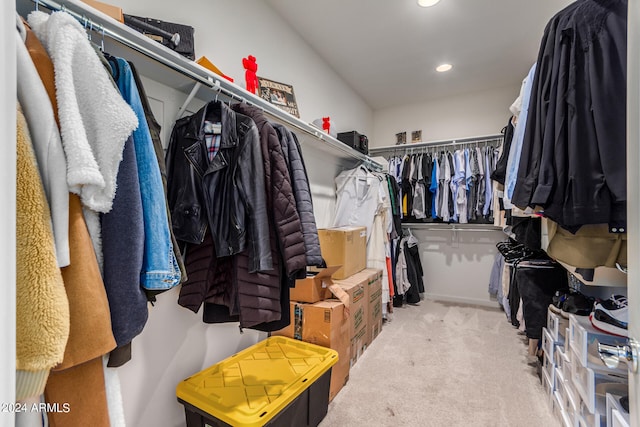 walk in closet with light colored carpet