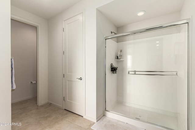 bathroom with tile patterned flooring and a shower with door