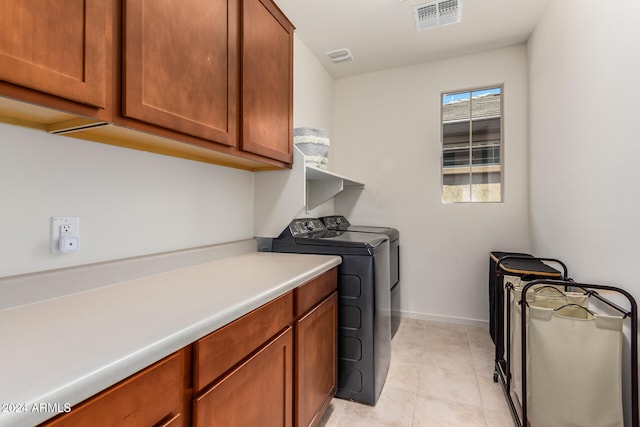 laundry area featuring cabinets, washing machine and clothes dryer, and light tile patterned flooring