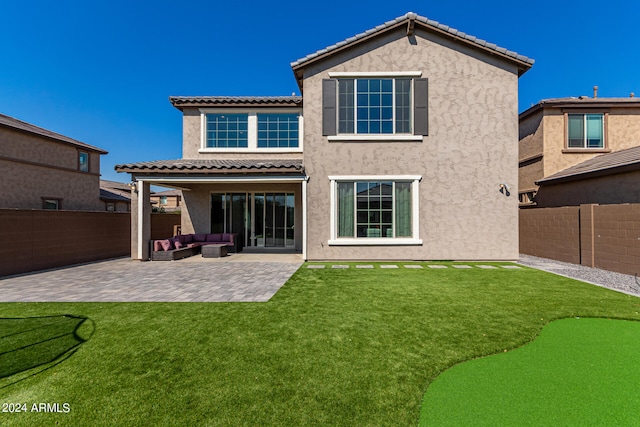 back of house featuring a lawn and a patio area