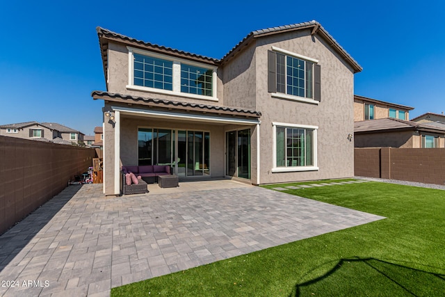 back of house featuring a lawn and a patio area