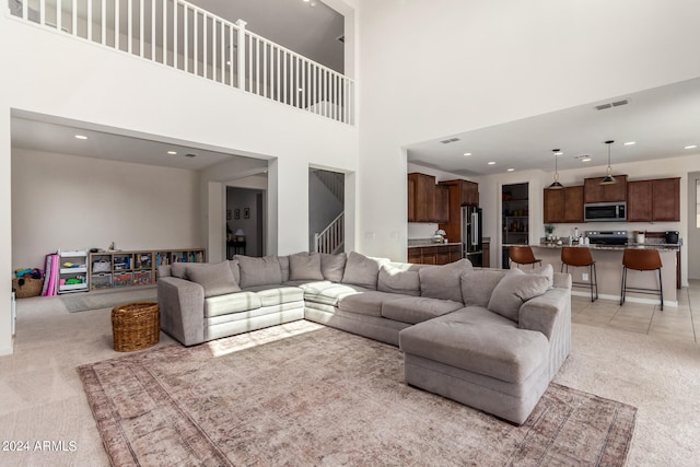 living room with a high ceiling and light carpet