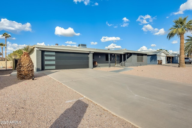 ranch-style house featuring a garage and central AC