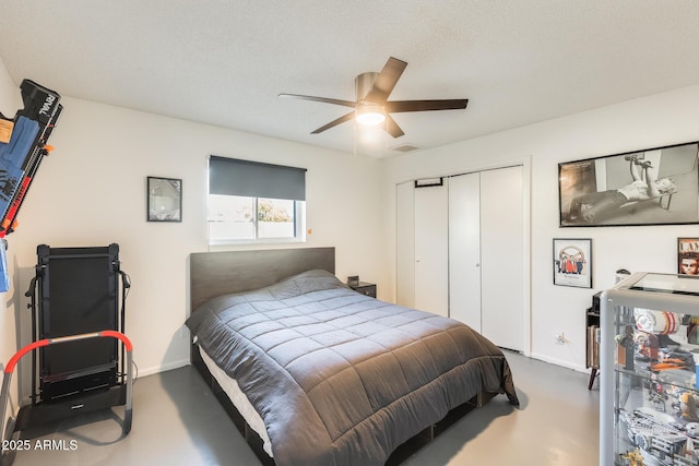 bedroom featuring ceiling fan, concrete flooring, a closet, and a textured ceiling