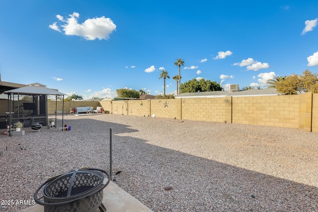 view of yard with a fire pit, a gazebo, and a patio area